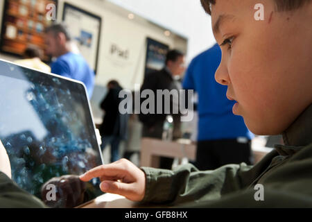 Un ragazzino tenta di eseguire un Apple iPad in un Apple store. Marzo 2010. Foto Stock