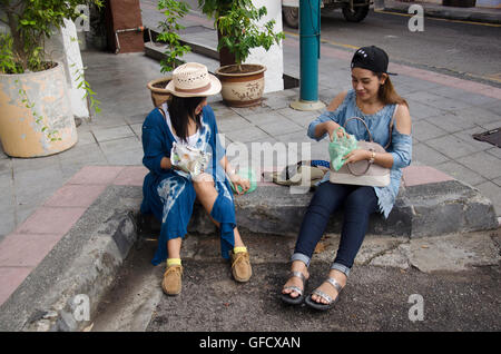 Tailandese donne mangiare il riso condito curry malese stile accanto alla strada di Georgetown di Penang in Malesia. Foto Stock