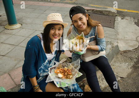 Tailandese donne mangiare il riso condito curry malese stile accanto alla strada di Georgetown di Penang in Malesia. Foto Stock