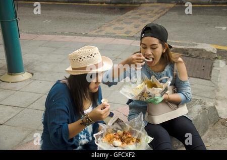 Tailandese donne mangiare il riso condito curry malese stile accanto alla strada di Georgetown di Penang in Malesia. Foto Stock