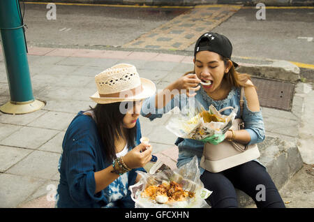 Tailandese donne mangiare il riso condito curry malese stile accanto alla strada di Georgetown di Penang in Malesia. Foto Stock