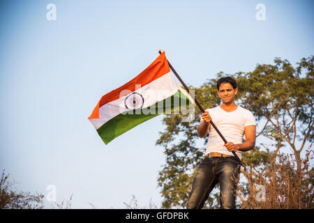 Indian giovane azienda e sventola bandiera indiana, immagine concettuale per il giorno della repubblica o il giorno di indipendenza, uomo bello holding bandiera, uomo indiano di contenimento Foto Stock