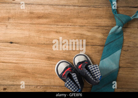 Padri giorno composizione della fascetta colorata prevista e scarpe per bambini su sfondo di legno Foto Stock