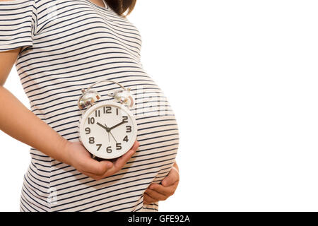 Donna incinta azienda orologio da parete. Si tratta di tempo. Isolato su bianco. Foto Stock