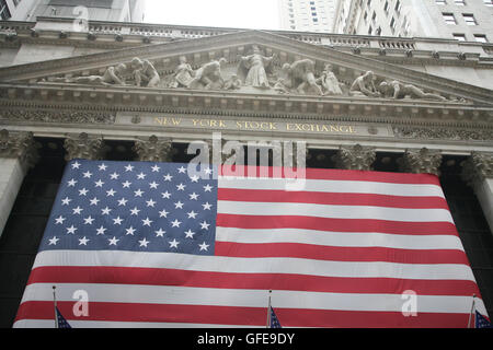 New York Stock Exchange a Wall Street con la bandiera americana su facciate Foto Stock