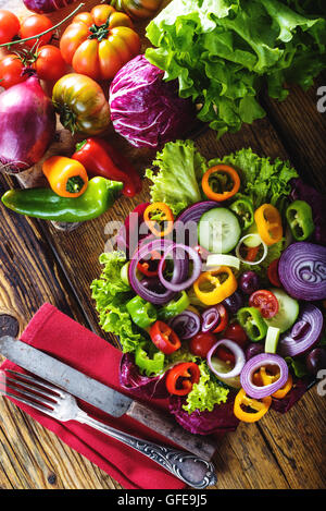 Insalata primaverile con fresche verdure succose su una tavola in legno rustico.