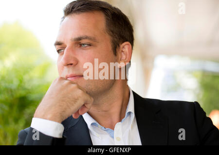 Close-up ritratto di un giovane uomo di affari in un abito scuro e camicia bianca Foto Stock