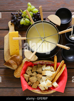 Tradizionale set di utensili per la fonduta, con pane, formaggio e uva Foto Stock