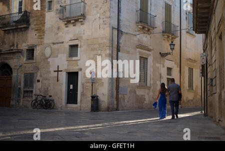 Due persone a piedi attraverso una stradina nel centro storico di Lecce, Puglia, Italia Foto Stock