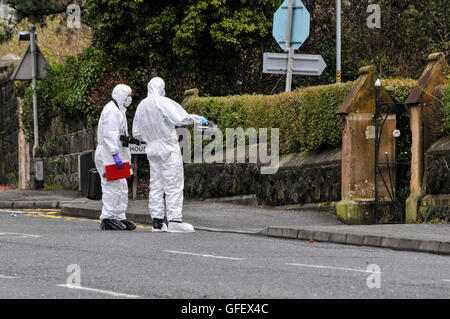 17/03/2013, Newtownabbey, Irlanda del Nord. Due ufficiali vestiti in abiti forense esaminare un dispositivo trovato nella motivazione di un romano cappella cattolica poco prima delle 9 del mattino. Foto Stock