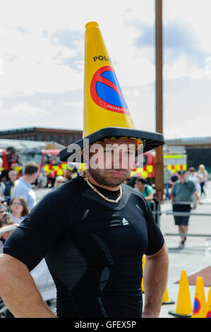 Belfast, Irlanda del Nord. 8 agosto 2013 - Un concorrente gioca con un cono di polizia al Ultimate Firefighter evento mondiale, la polizia e i Vigili del Fuoco (giochi WPFG) Foto Stock