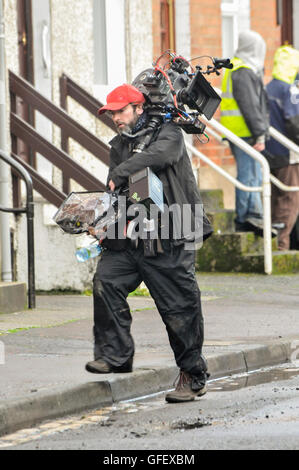 Belfast, Irlanda del Nord. 18 dic 2014 - un cameraman porta un filmato video di qualità della fotocamera. Foto Stock