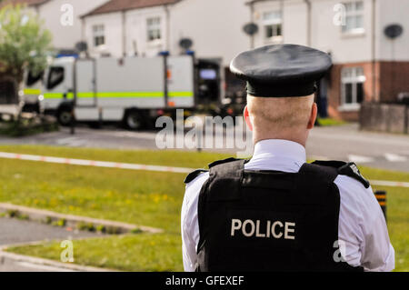 17 maggio 2013, Belfast, Irlanda del Nord. Un PSNI funzionario di polizia custodisce le cordon perimetro mentre soldati dell'Esercito britannico "Bomb Squad' rendere sicura una improvvisata dispositivo esplosivo. Foto Stock