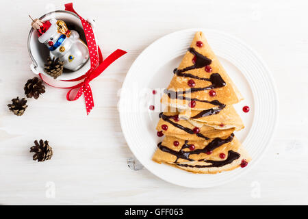 Albero di natale a forma di frittelle dolci sul tavolo di legno per la colazione, tratta, vista dall'alto Foto Stock