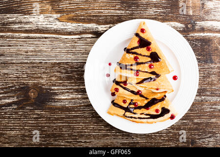 Albero di natale a forma di frittelle dolci sul tavolo di legno per la colazione, tratta, vista dall'alto Foto Stock