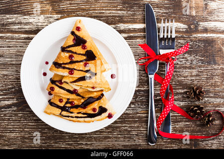 Albero di natale a forma di frittelle dolci sul tavolo di legno per la colazione, tratta, vista dall'alto Foto Stock