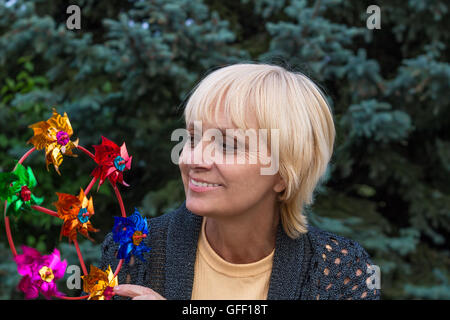 Felice donna anziana sorrisi e gioca con elica Foto Stock