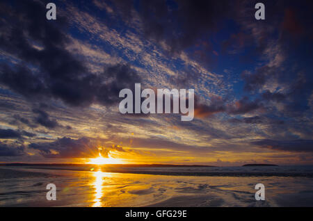 Tramonto a Penmaenmawr spiaggia verso Anglesey Foto Stock