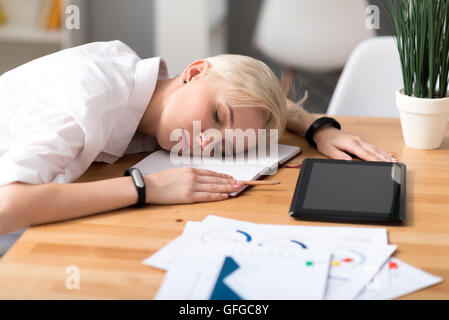 Donna che Dorme sul tavolo durante il lavoro Foto Stock