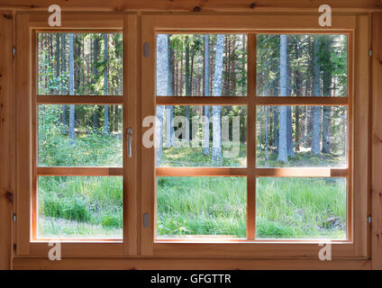 Verde soleggiata vista dell'estate boschi nel paese in legno finestra. Foto Stock