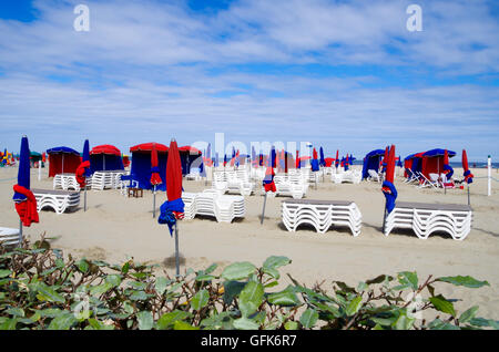 Spiaggia vuota a Deauville in attesa del primo lucertole da mare con ombrelloni da spiaggia e ombrelloni nonché di pile di sedie da spiaggia Foto Stock