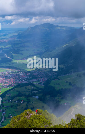 Alpinismo Femminile in Algovia montagne con townscape di Oberstdorf in background, Germania Foto Stock