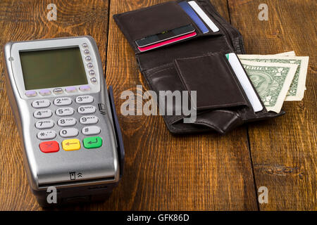 Pagamento terminale senza fili e il portafoglio con banconote Foto Stock