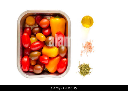 Monouso di alluminio vassoio di cottura alla griglia con un assortimento di pomodori ciliegia e piccoli peperoni pronti per la cottura Foto Stock