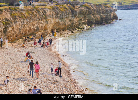 I turisti sulla spiaggia di ciottoli a Chersonesus sulla costa del Mar Nero, Crimea Foto Stock