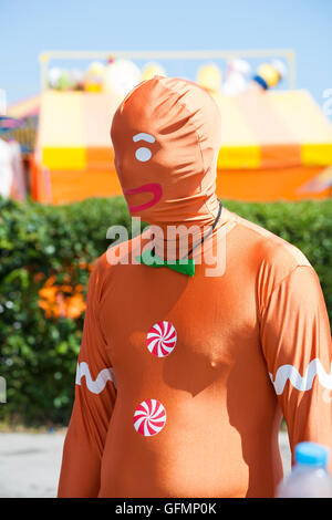 Swanage, Dorset, Regno Unito. 31 Luglio, 2016. Caldo e soleggiato Porta schiere di visitatori a Swanage per guardare la processione parade, come parte di Swanage la settimana di carnevale. Il tema di quest anno è Sitcoms. Gingerbread Man - tuta di morphing. Credito: Carolyn Jenkins/Alamy Live News Foto Stock