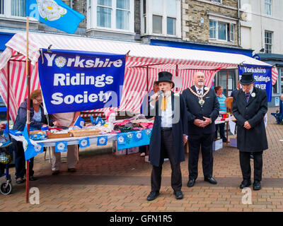 Redcar, North Yorkshire, Regno Unito. Il 1 agosto, 2016. Celebrazione della Giornata dello Yorkshire con il sindaco di Redcar Assessore Barry Hunt affiancato da due attori nella parte del XIX secolo Henry Ironmasters Bolckow e John Vaughan fondatori dell'industria del ferro su Teesside. Attore Chris Foote-Wood, fratello del tardo attrice Victoria Wood, (sinistra) giocando Bolckow legge il Yorkshire Dichiarazione di integrità, che Yorkshire consiste in tre circoscrizioni e la città di York e dichiara fedeltà alla Regina. Credito: Pietro Giordano NE/Alamy Live News Foto Stock