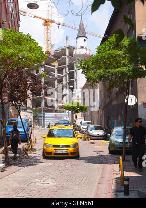 Istanbul, Turchia - 1 Luglio 2016: giallo taxi auto va sulla stradina nel centro storico di Istanbul, la gente comune a piedi sul ciglio della strada Foto Stock