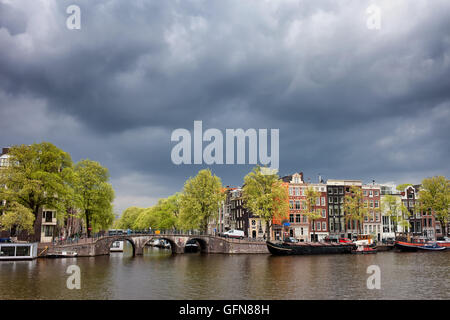 Skyline della città di Amsterdam in Olanda, Paesi Bassi, case olandesi tradizionali lungo il fiume Amstel, ponte sul canale Prinsengracht, c Foto Stock