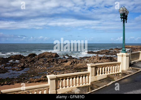 Balaustra con lampada di strada lungo la costa rocciosa dell'Oceano Atlantico in Foz do Douro, Porto, Portogallo, Europa Foto Stock