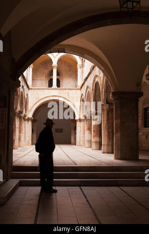 Uomo in Hat sotto Archway, Città Vecchia, Dubrovnik Foto Stock