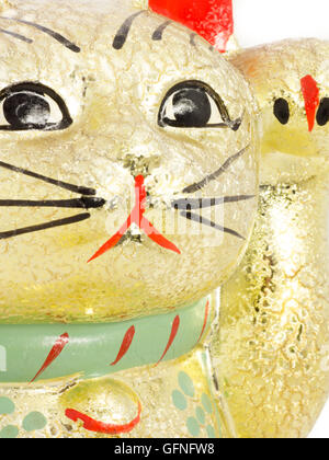 Oro indicandovi giapponese cat chiamato Manekineko bianco su sfondo isolato Foto Stock