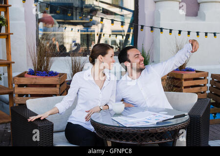 Happy business giovane tenendo selfie presso un ristorante esterno Foto Stock