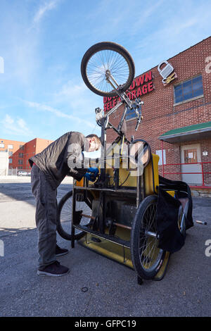 Noleggio taxi driver che fissa il suo veicolo, sale come City, Stati Uniti d'America Foto Stock