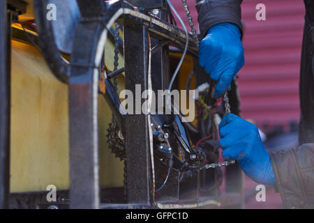 Noleggio taxi driver che fissa il suo veicolo, sale come City, Stati Uniti d'America Foto Stock