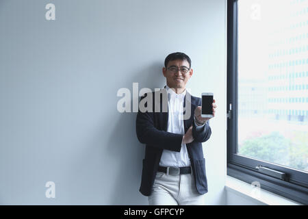 Imprenditore giapponese in un ufficio moderno Foto Stock