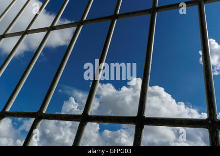 Visualizzare attraverso il carcere della finestra sul cielo blu sullo sfondo Foto Stock