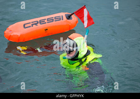 Scuba Diver in colorato fluorescente in marcia mare azienda Cressi siluro galleggiante a Swanage in luglio Foto Stock