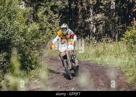 Racer su un motociclo su sterrato in gara nella foresta durante l'Ural Cup di Enduro Foto Stock