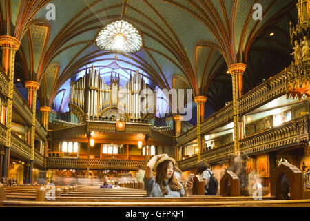 Montreal la Basilica di Notre Dame interno - il giovane turista femminile di origine asiatica prendendo un selfie Casavant con organo a canne dietro Foto Stock