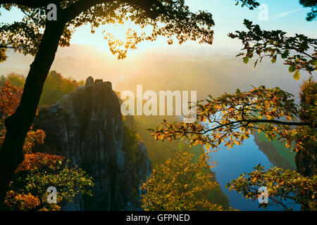 Vista nella profonda valle misty nella Svizzera sassone. Picchi di arenaria è aumentato da sfondo velato Foto Stock