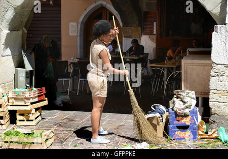 Donna mercato titolare di stallo di spazzamento stradale pulizia eliminazione rifiuti rifiuti a Annecy in Francia Foto Stock