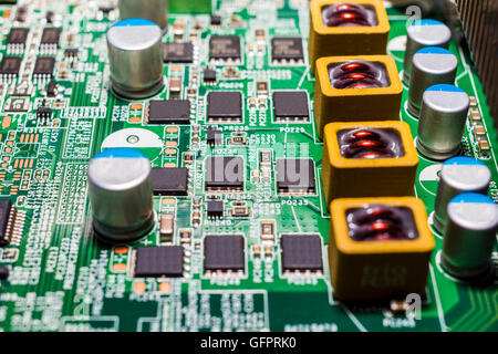 Immagine ravvicinata di microchip e resistenze su una scheda a circuito stampato, potrebbe rappresentare l'industria elettronica Foto Stock