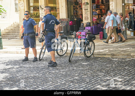 Corfù, Grecia - 11 giugno 2016. Gli ufficiali di polizia mantenendo una stretta e occhi attenti su persone sulle strade Foto Stock