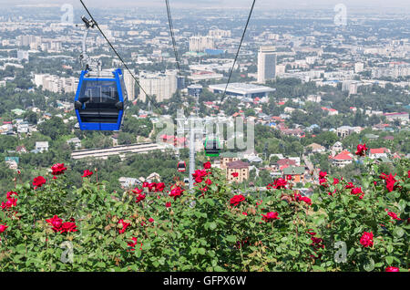 Vista panoramica della città di Almaty con fiori che sbocciano in primo piano. Foto Stock