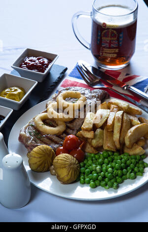 Un tradizionale pub inglese/bar piatto di carne bovina britannica Scamone bistecca con patatine/patatine fritte e verdure e condimenti. Foto Stock